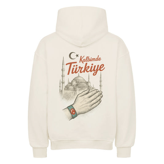 Weißer Oversized Hoodie von Pelasgia mit Kalbimde Türkiye-Print, bequemes Design, sichtbarer Hoodie-Kragen und Druck auf der Vorderseite.